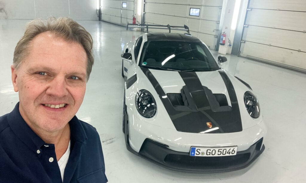En man står bredvid en Porsche GT3 RS. (AI text)