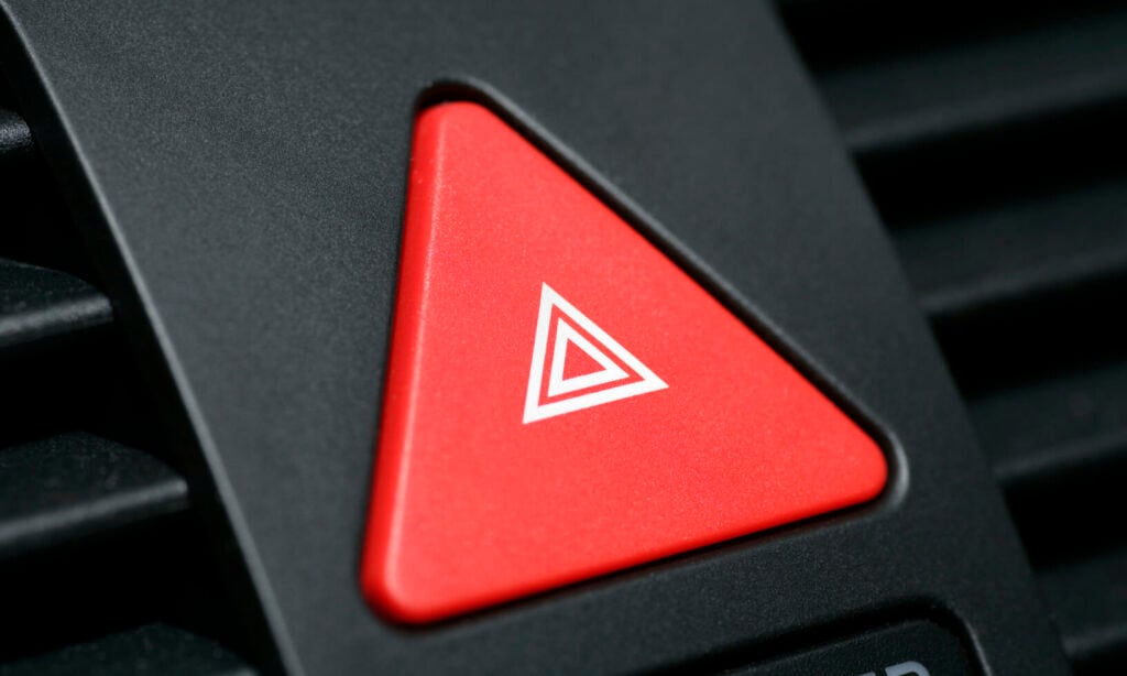 En röd triangelform på en bilinstrumentbräda. (AI text)