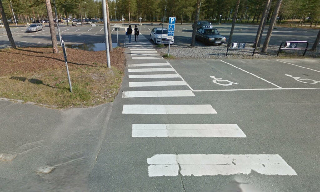 Sveriges kanske längst övergångsställe krokar sig över en parkering.