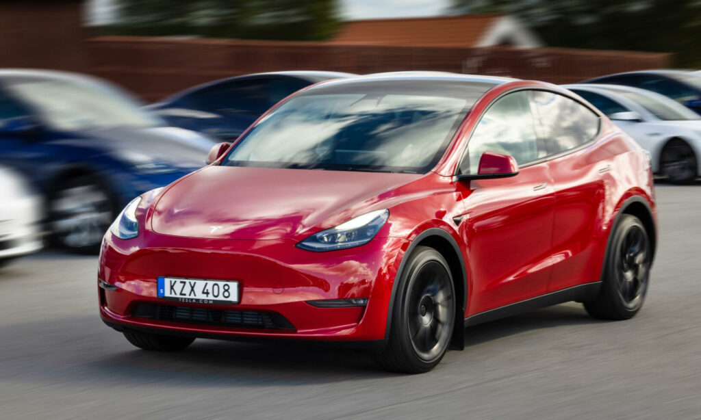Tesla Model Y kör i ett parkeringsområde (AI text)