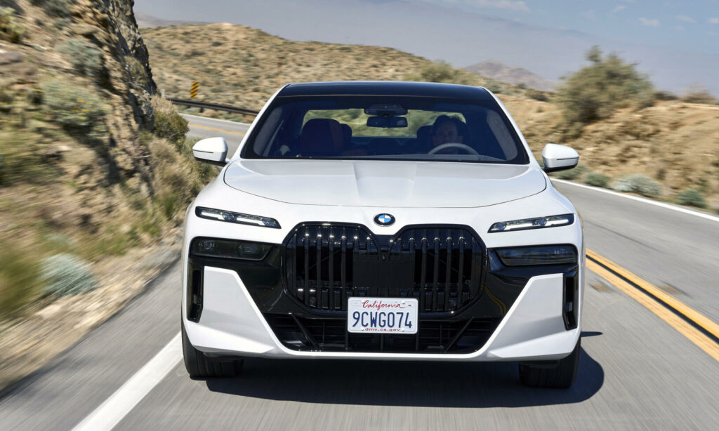 BMW X7 SUV kör nerför en bergsväg. (AI text)