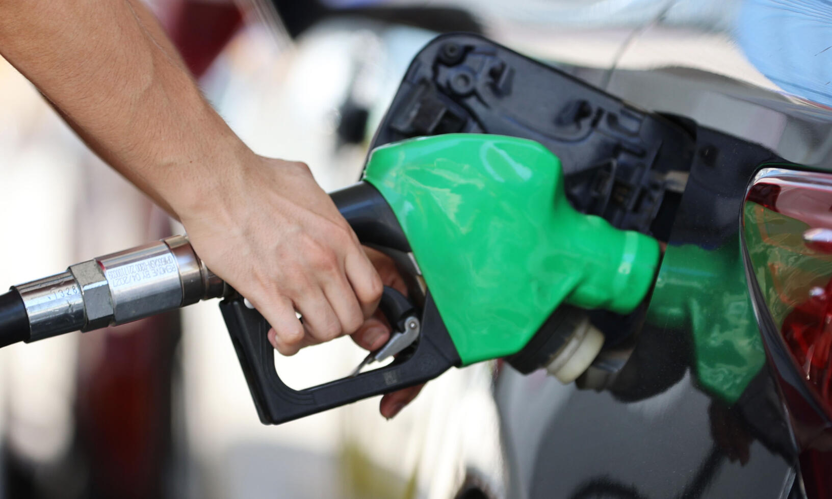 En man tankar upp sin bil med bränsle på en bensinstation. (AI text)