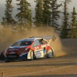 En rallybil kör nerför en backe. (AI text)