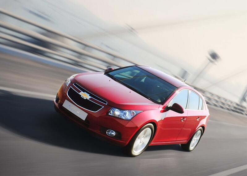 En röd Chevrolet Cruze kör över en bro. (AI text)