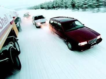 En bil kör nerför en snöig väg. (AI text)