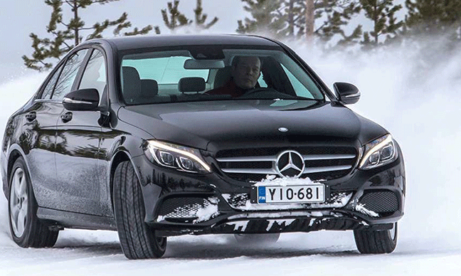 Mercedes C-klass kör i snö. (AI text)