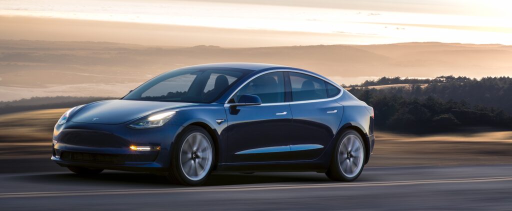 Tesla Model 3 kör på en bergväg (AI text)