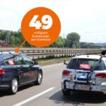 En bil kör nerför vägen med en cykel fastmonterad på den. (AI text)