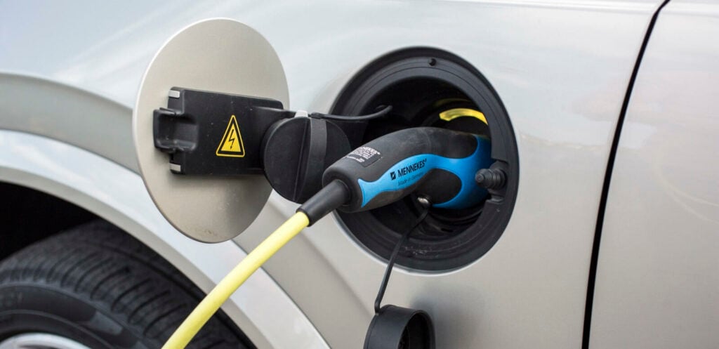 En bil är uppkopplad till en elladdare. (AI text)