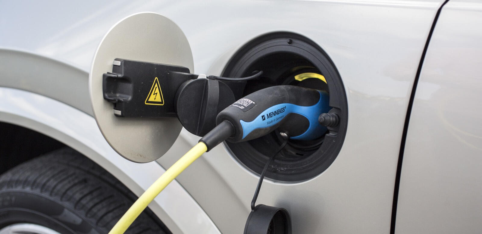 En bil är uppkopplad till en elladdare. (AI text)