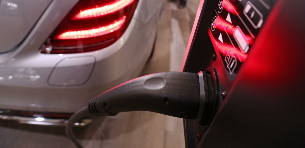 En bil är uppkopplad till en elladdare. (AI text)