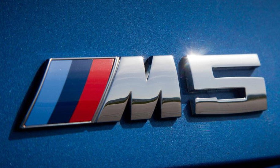 BMW M5-badgen på en blå bil (AI text)