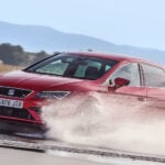 En röd bil kör på en våt bana. (AI text)