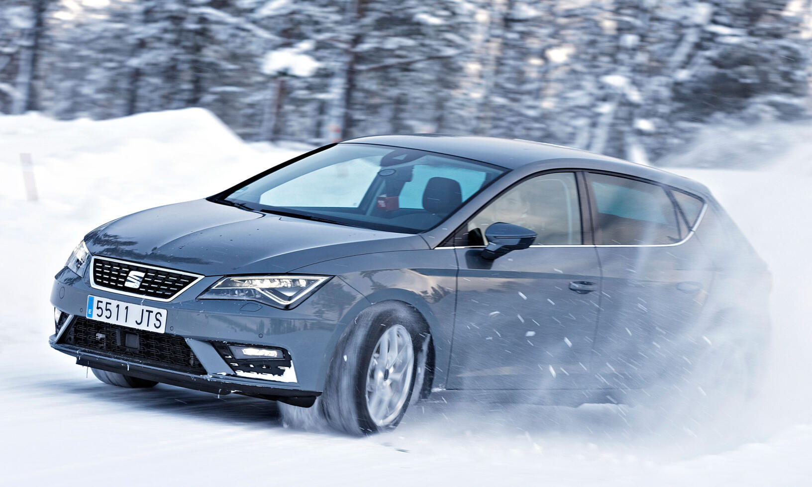 En Seat Leon körande genom snön. (AI text)