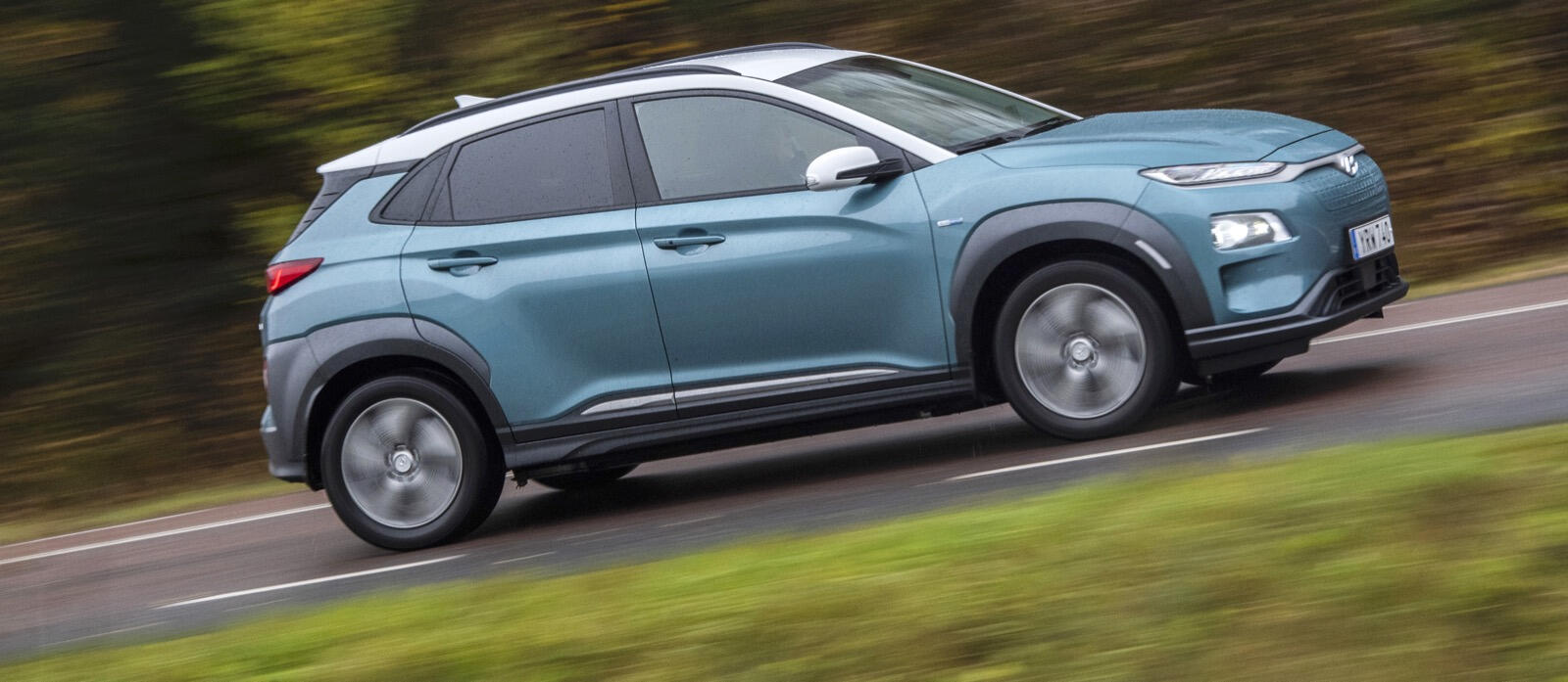 Hyundai Kona kör nedför en landsväg. (AI text)