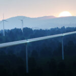 En vindkraftverk syns i fjärran. (AI text)