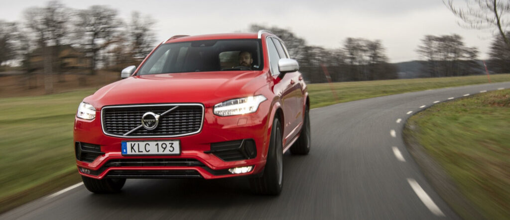 Volvo XC90-fordonet kör längs en landsväg. (AI text)