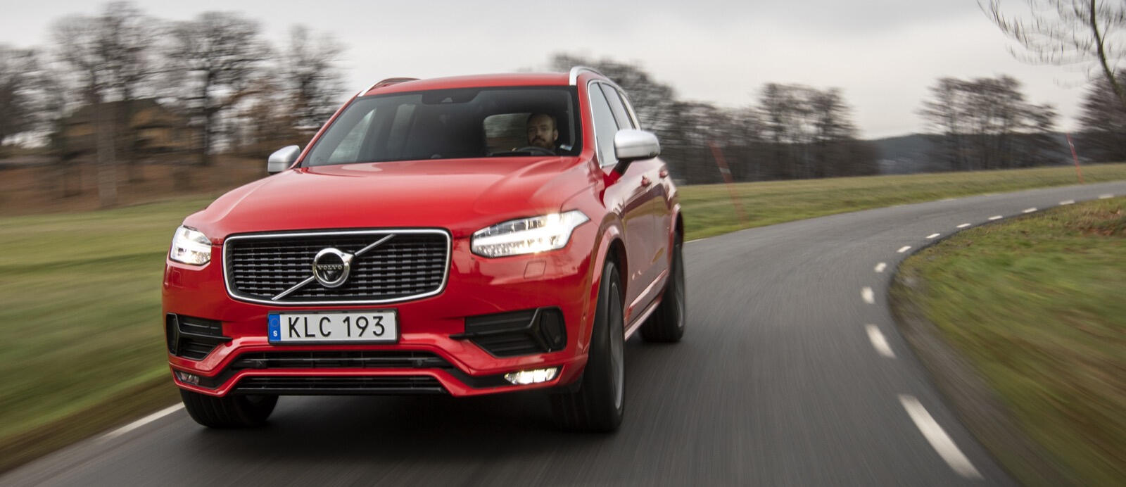 Volvo XC90-fordonet kör längs en landsväg. (AI text)