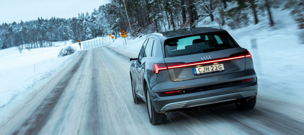 en SUV körande längs en snöig väg (AI text)