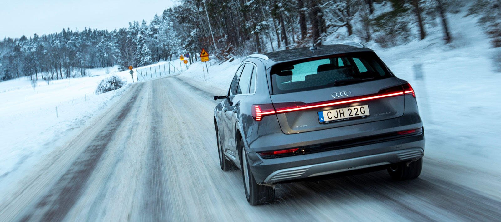 en SUV körande längs en snöig väg (AI text)