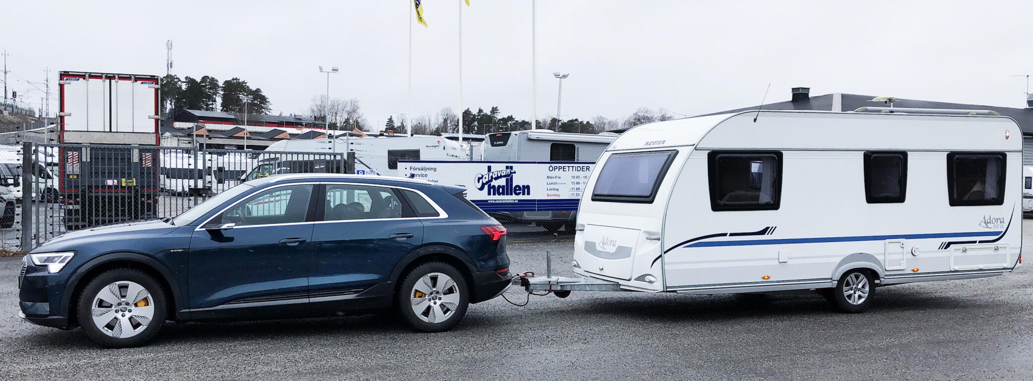 En bil står parkerad bredvid ett släp. (AI text)