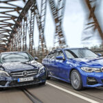 Två Mercedes-Benz E-klass-sedanter kör över en bro. (AI text)