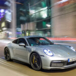 Porsche 911 GTS kör längs gatan på natten. (AI text)