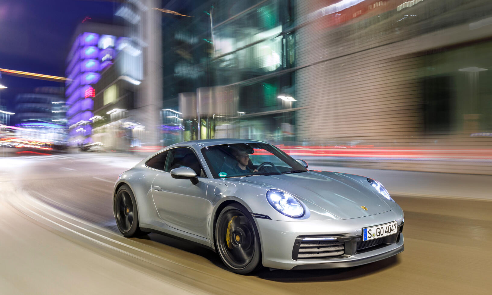 Porsche 911 GTS kör längs gatan på natten. (AI text)