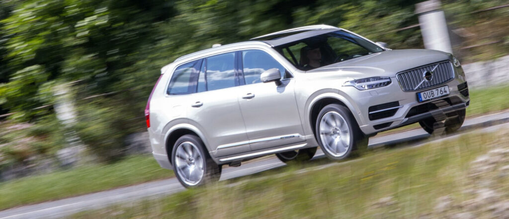 Volvo XC90 SUV kör längs en landsväg. (AI text)