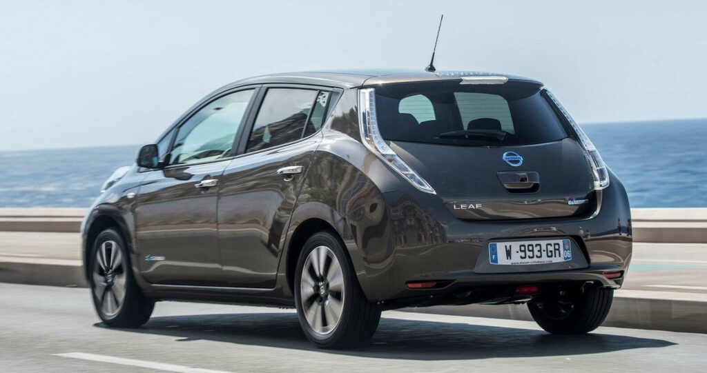 En Nissan Leaf elbil kör längs en väg. (AI text)