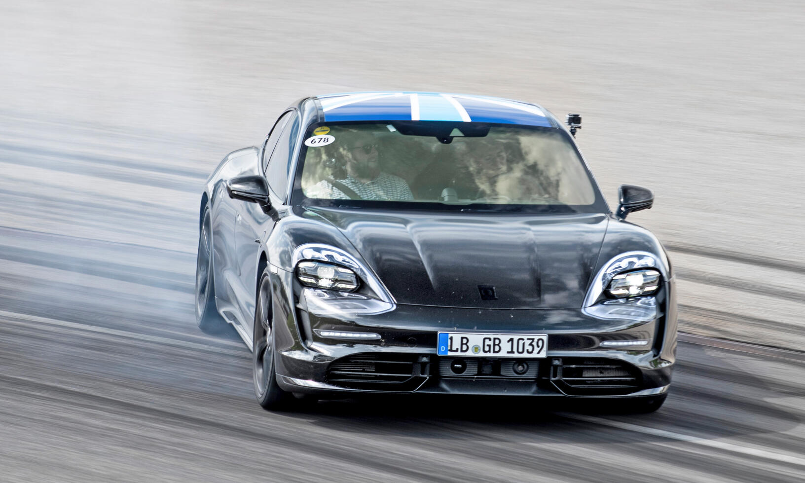 En Porsche Macan kör på en racingbana. (AI text)