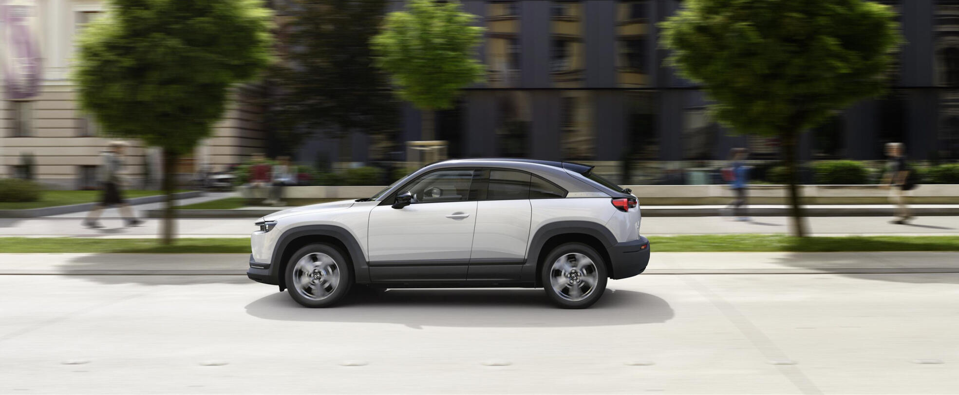 En vit SUV kör nerför en stadsgata. (AI text)