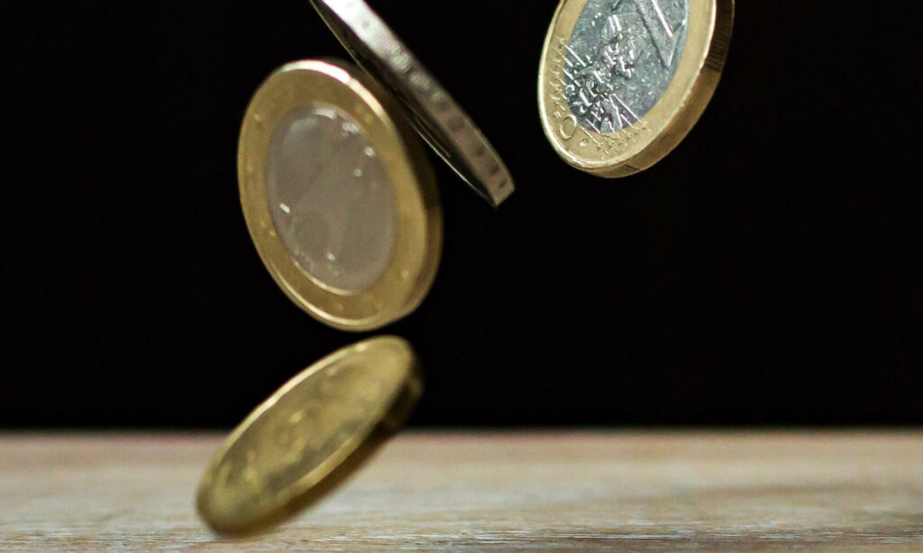 En man fyller på med mynt i en burk. (AI text)