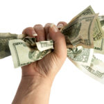 En kvinna håller en knyppla pengar i sin hand. (AI text)