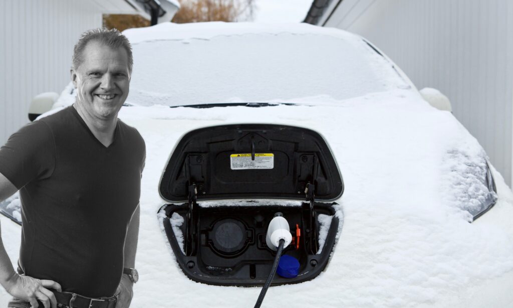 En man står bredvid en bil som är täckt av snö. (AI text)