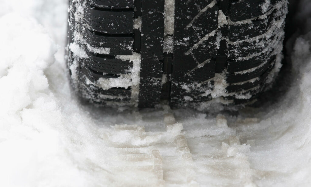 En bil kör på snöiga vägar. (AI text)