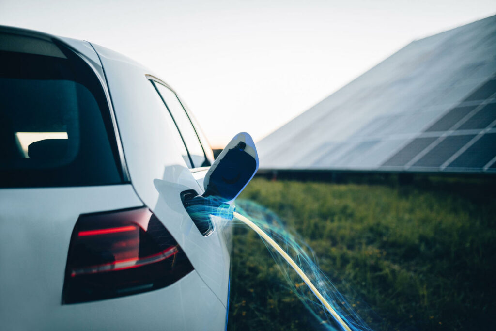 en bil laddar vid en solpanelsskog (AI text)
