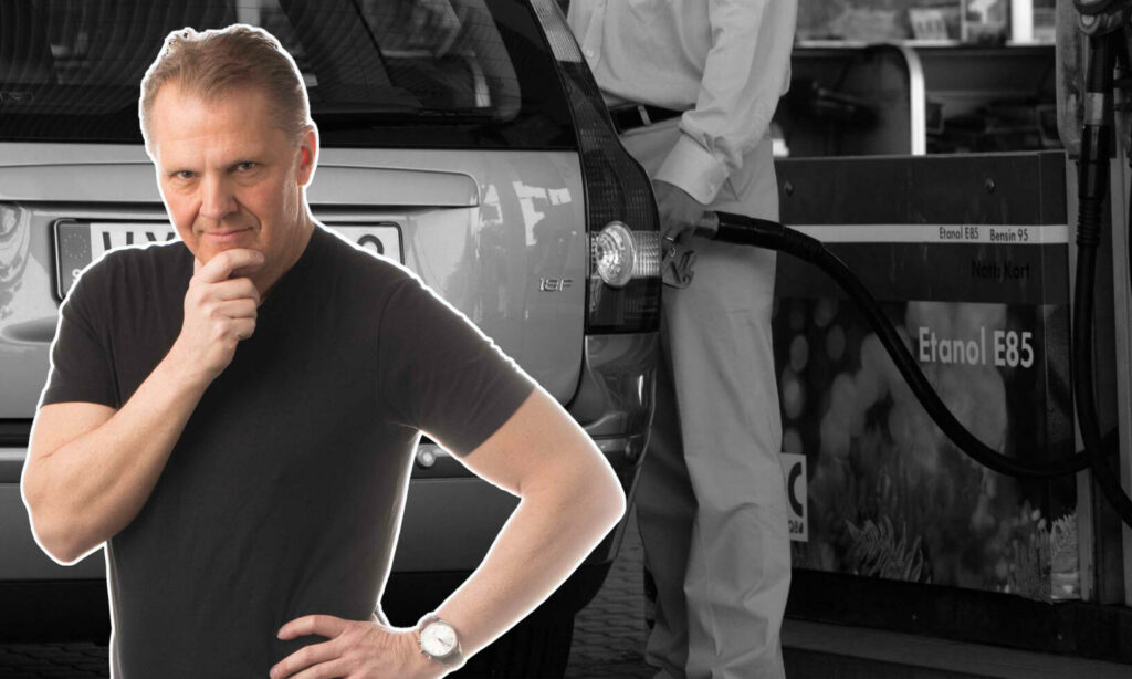 En man står bredvid en bil på en bensinstation. (AI text)