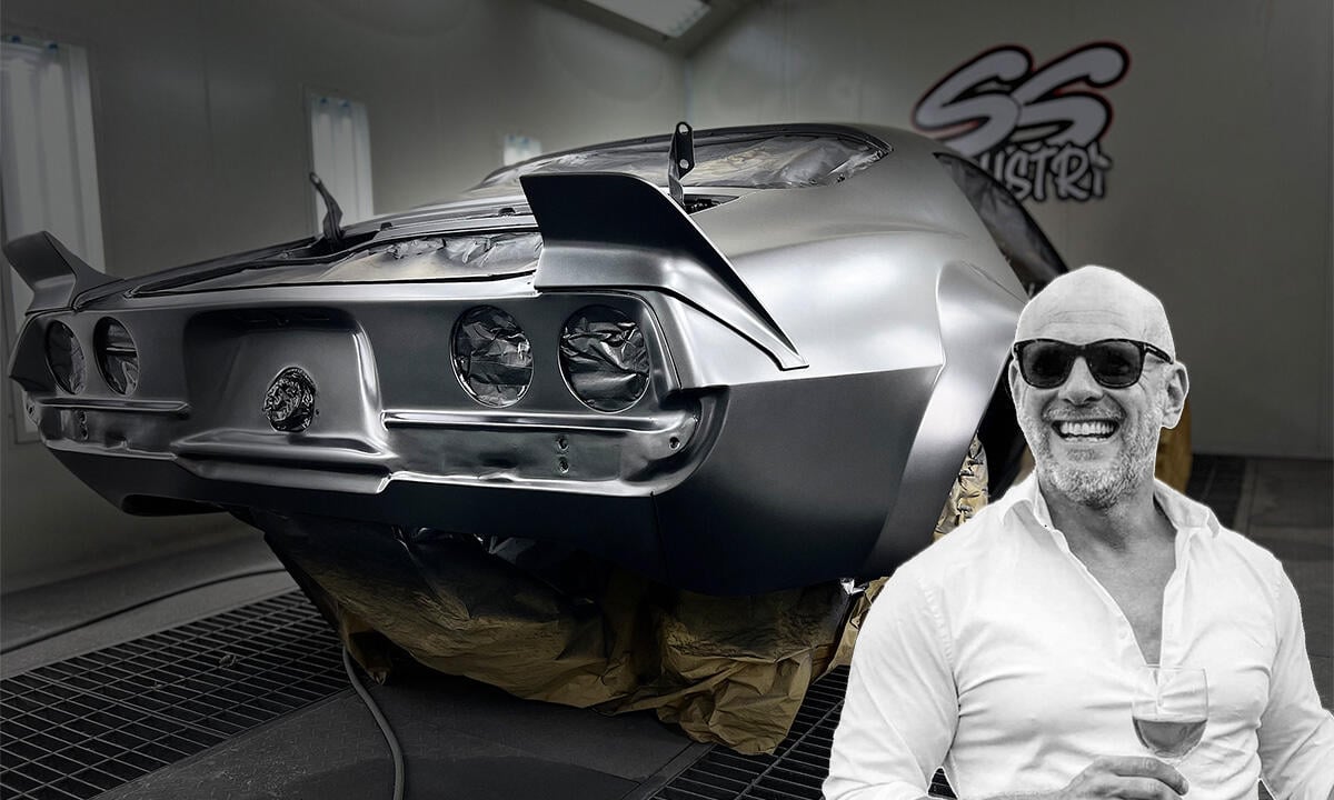 En man står bredvid en bil i en garage. (AI text)