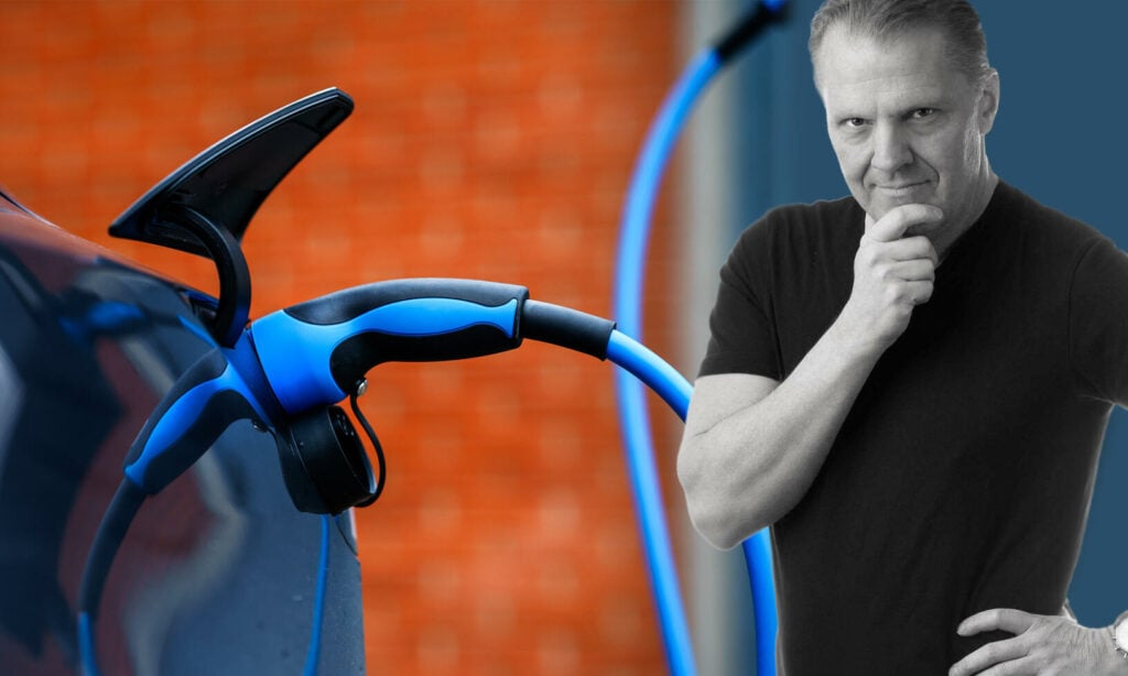 En man står bredvid en bil och laddar den. (AI text)