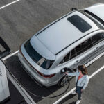 En kvinna laddar sin bil på en elbilsladdstation. (AI text)