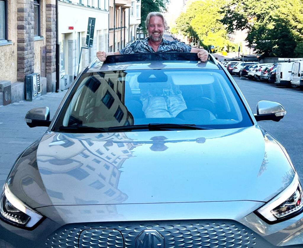 En nöjd layoutare med sin elbil.