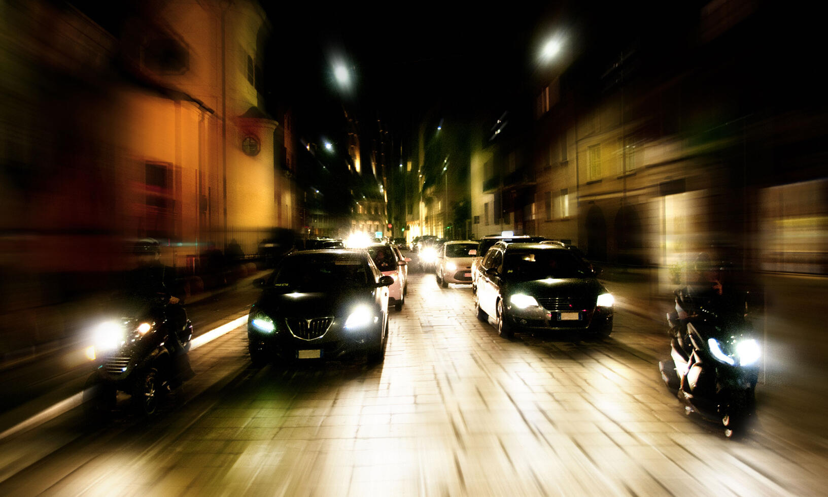 En suddig bild av en stadsgata på natten. (AI text)