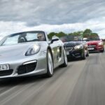 En grupp bilar kör längs en landsväg. (AI text)