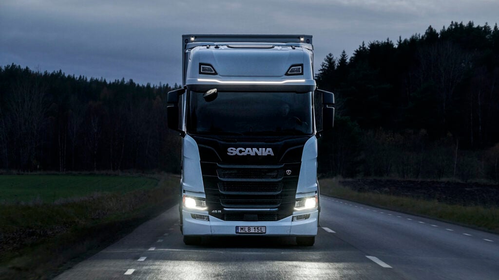 En lastbil kör nedför en landsväg på natten. (AI text)