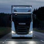 En lastbil kör nedför en landsväg på natten. (AI text)