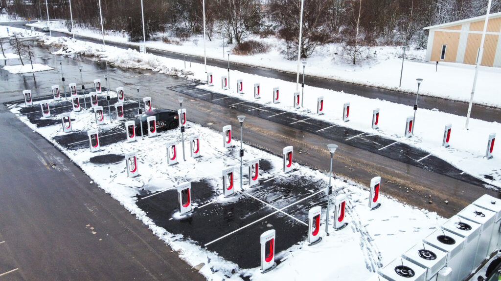 En bil laddar i en parkeringsplats under vinterperioden. (AI text)