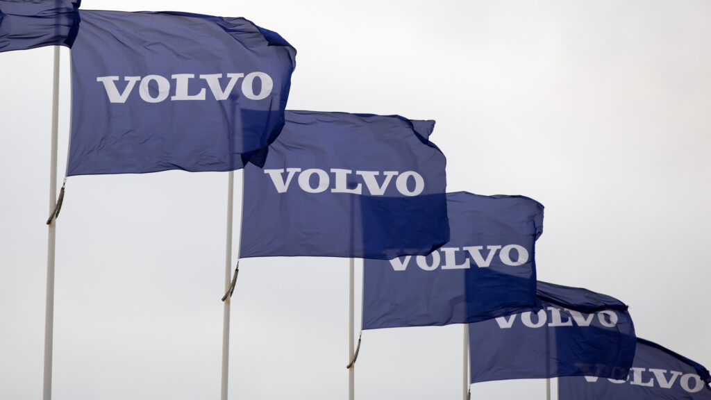 Volvo-logotyperna fladdrar i vinden. (AI text)