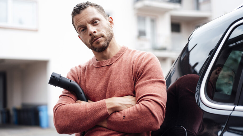 En man står bredvid sin bil. (AI text)