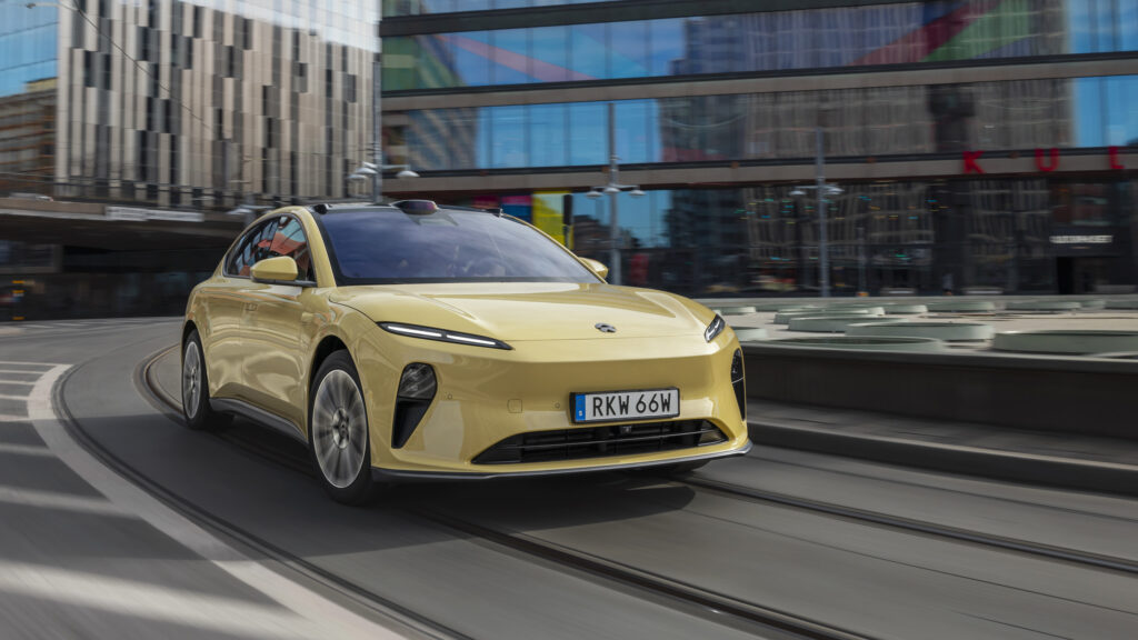 En gul elbil kör nedför en stadsgata. (AI text)